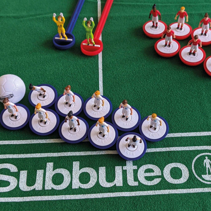 Subbuteo Lionesses Main Game with player figurines on a green pitch featuring the Subbuteo logo.